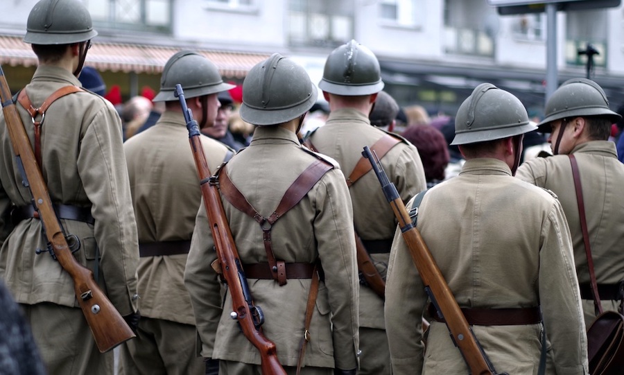 Vojáci v uniformě stojící mezi lidmi.